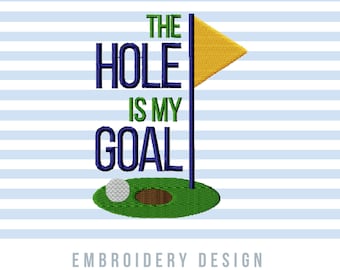May include: Embroidery design featuring a golf flag with a yellow flag, a green golf course, and a golf ball. The text "The Hole Is My Goal" is in blue.
