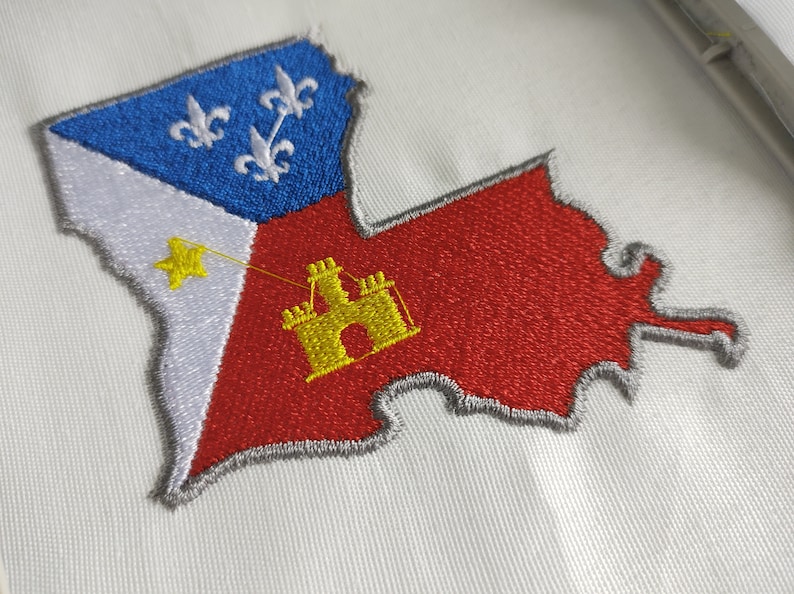 Pode incluir: Um remendo bordado do estado da Louisiana. O remendo &eacute; vermelho, branco e azul com uma estrela amarela e um castelo amarelo no centro. O contorno do estado &eacute; cinza.