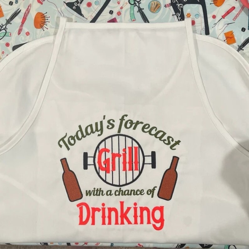 May include: White apron with the text "Today's forecast Grill with a chance of Drinking" in green, black, and red lettering. The text is surrounded by a graphic of a grill and two beer bottles.