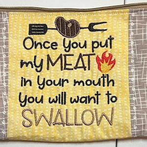 May include: A yellow fabric zipper pouch with a brown and white checkered border. The pouch has a white embroidered design with the text "Once you put my MEAT in your mouth you will want to SWALLOW". The design also includes a red and yellow flame and a black silhouette of a spatula, a steak, and a fork.