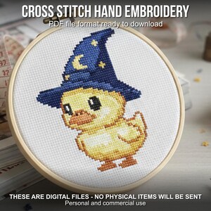 May include: Cross stitch embroidery of a yellow duckling wearing a blue wizard hat with a crescent moon and stars. The design is in a wooden embroidery hoop. Text at the top reads "CROSS STITCH HAND EMBROIDERY". Text at the bottom reads "THESE ARE DIGITAL FILES - NO PHYSICAL ITEMS WILL BE SENT".
