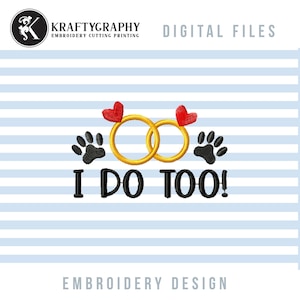 May include: Embroidery design featuring two gold rings with red hearts and two black paw prints. The text "I DO TOO!" is below the rings.