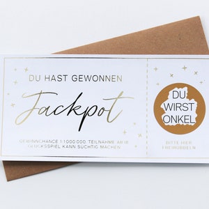 May include: A white rectangular scratch-off lottery ticket with gold foil accents and text that reads DU HAST GEWONNEN Jackpot, DU WIRST ONKEL, and BITTE HIER FREIRUBBELN, placed on top of a brown envelope. The ticket features small gold star graphics.