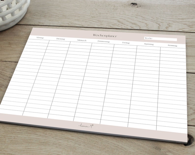 May include: A blank weekly planner with a light brown background and the word "Wochenplaner" at the top. The planner has columns for each day of the week, Monday through Sunday, with the days labelled in German.