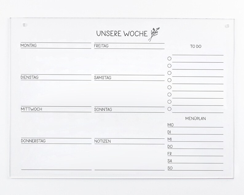 May include: A white acrylic dry erase board with a weekly planner layout. The board has sections for Monday through Sunday, a to-do list, and a meal plan. The text "UNSERE WOCHE" is at the top of the board.