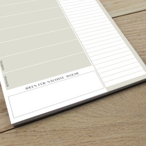 May include: A weekly planner with a light gray background and black lines. The days of the week are listed in German: Sonntag, Montag, Dienstag, Mittwoch, Donnerstag, Freitag, Samstag. The planner has a section at the bottom labeled "Ideen f&uuml;r n&auml;chste Woche" for writing down ideas for the next week.