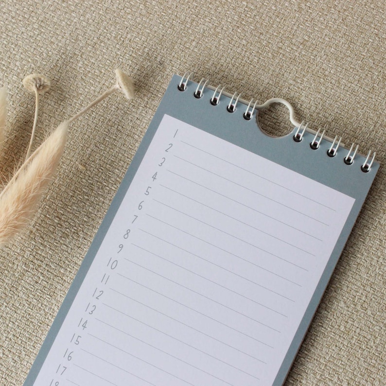 May include: A gray spiral bound notepad with a white lined interior. The notepad has numbers 1 through 19 listed down the left side.