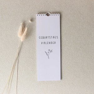 May include: A white calendar with a black floral design and the text "Geburtstagskalender" on a beige background.