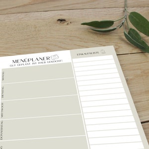 May include: A beige printable meal planner and grocery list. The meal planner has spaces for Monday, Tuesday, Wednesday, Thursday, Friday, Saturday, and Sunday. The grocery list has a shopping bag icon.