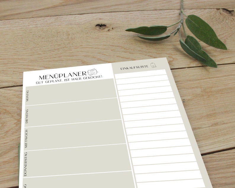 May include: A beige printable meal planner and grocery list. The meal planner has spaces for Monday, Tuesday, Wednesday, Thursday, Friday, Saturday, and Sunday. The grocery list has a shopping bag icon.