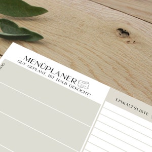 May include: A beige printable meal planner with the text "MEN&Uuml;PLANER GUT GEPLANT. IST HALB GEKOCHT!" and a shopping list section with the text "EINKAUFLISTE".