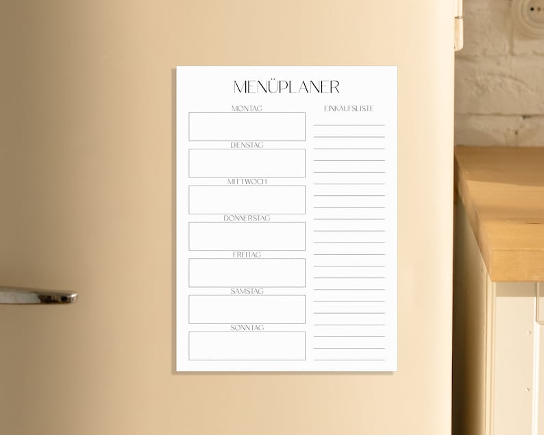 May include: A white magnetic menu planner with the German word "MEN&Uuml;PLANER" at the top. The planner has spaces to write in the meals for each day of the week: Monday, Tuesday, Wednesday, Thursday, Friday, Saturday, and Sunday.  The planner also has a section for a grocery list.