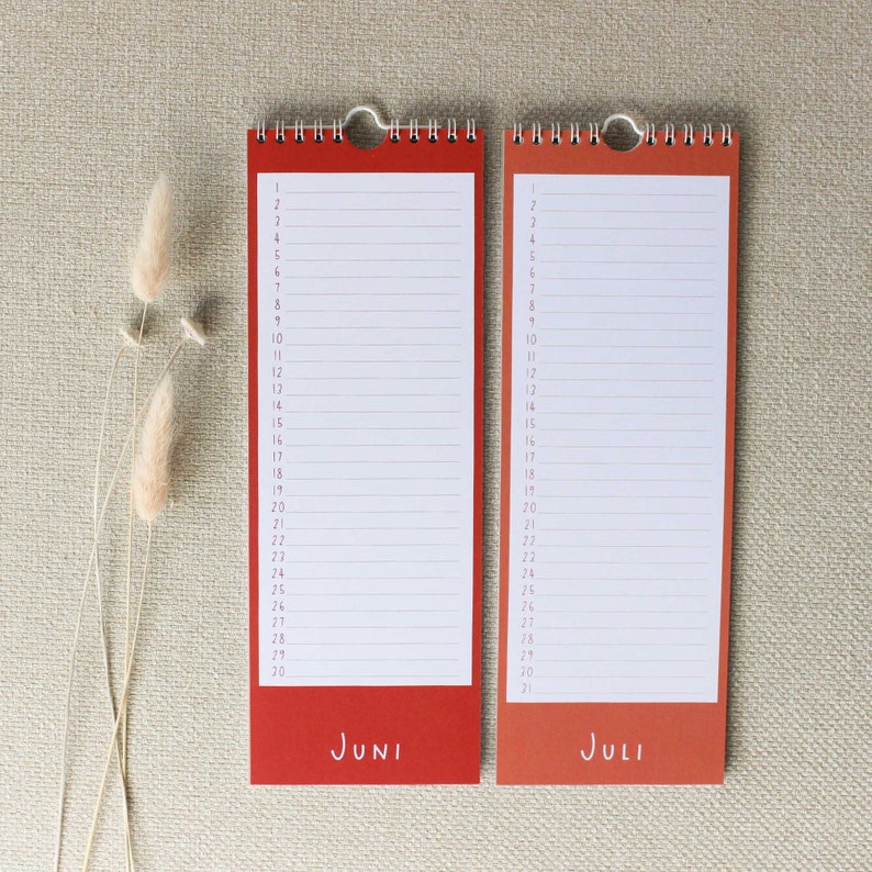May include: Two red and orange monthly calendar pages with the months of June and July printed on them. The pages are numbered 1 through 30 and 31, respectively.