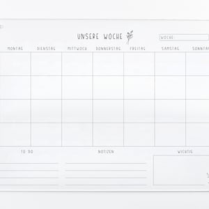 May include: A white acrylic weekly planner with a grid layout for each day of the week, labeled in German. The days of the week are: Montag, Dienstag, Mittwoch, Donnerstag, Freitag, Samstag, Sonntag. The planner also includes sections for "To Do", "Notizen" (notes), and "Wichtig" (important).