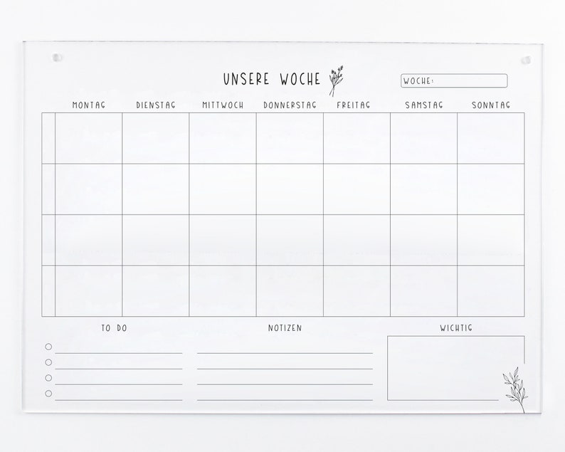 May include: A white acrylic weekly planner with a grid layout for each day of the week, labeled in German. The days of the week are: Montag, Dienstag, Mittwoch, Donnerstag, Freitag, Samstag, Sonntag. The planner also includes sections for "To Do", "Notizen" (notes), and "Wichtig" (important).