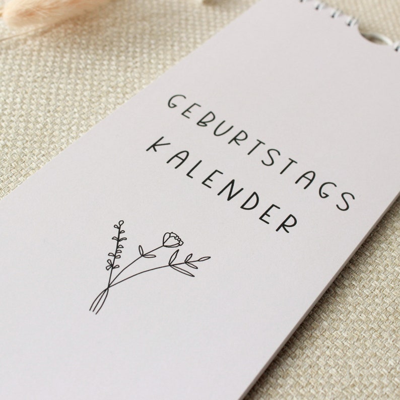 May include: A light gray birthday calendar with the text "Geburtstagskalender" and a simple line drawing of a flower.