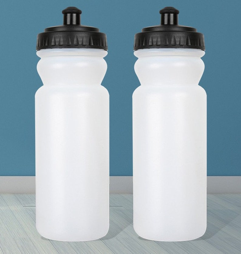 Puede incluir: Dos botellas de agua de pl&aacute;stico blanco con tapas negras y una superficie texturizada.