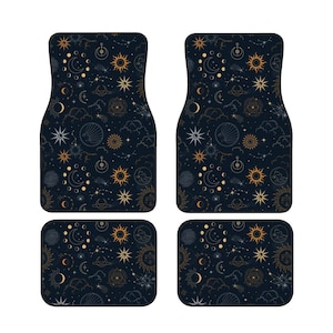 May include: Four car floor mats with a celestial design. The mats have a dark blue background with gold and white illustrations of the sun, moon, stars, and constellations. Includes two larger mats and two smaller mats.