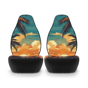 May include: Two black car seat covers with a sunset and palm tree design. The design features a blue sky, orange clouds, and a yellow sunset.