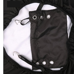 May include: Black car seat cover with elastic straps and a built-in pocket. The cover has a white fleece lining and multiple metal grommets.