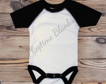 May include: White baby onesie with black raglan sleeves and black trim around the neckline and snaps. The onesie has the text "Playtime Blanks" printed on the front.