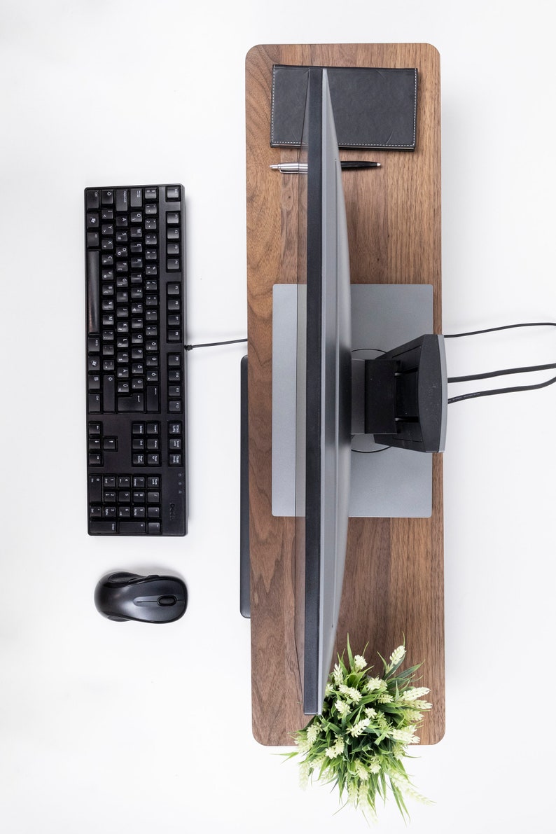 Puede incluir: Un teclado de ordenador negro, un rat&oacute;n y un monitor sobre un escritorio de madera con una peque&ntilde;a planta en maceta.