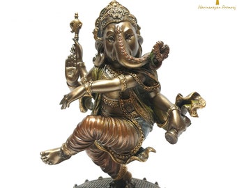 May include: A gold-toned statue of Ganesha, the Hindu god of wisdom and prosperity, dancing on a lotus base. The statue is intricately detailed with colorful accents and a flower in Ganesha's trunk.