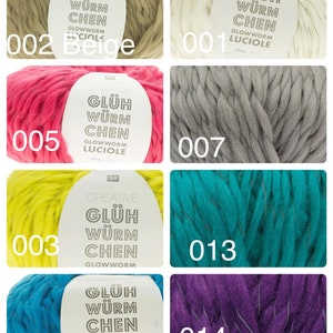 May include: Assortment of yarn skeins in various colours, including beige, pink, yellow, turquoise, teal, and purple. Each skein features a label with the text "GLÜH WÜRM CHEN GLOWWORM LUCIOLE" and a number code.
