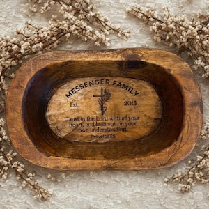 May include: A rustic, oval-shaped wooden bowl with a dark brown finish. The center of the bowl is engraved with the text "MESSENGER FAMILY Est. 2015" and a cross design. The inscription reads "Trust in the Lord with all your heart, and lean not on your own understanding. Proverbs 3:5."