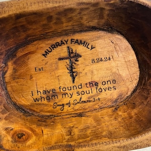 May include: A wooden serving bowl with a cross design and the text "MURRAY FAMILY Est. 8.24.24 I have found the one whom my soul loves Song of Solomon 3:4" engraved on the surface.