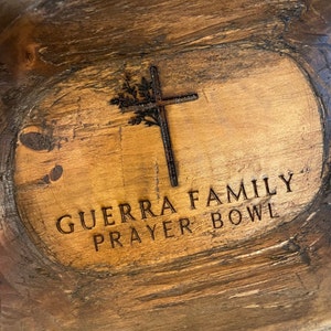 May include: A wooden prayer bowl with the words "Guerra Family Prayer Bowl" engraved on the front. A cross with a floral design is also engraved on the bowl.