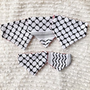 May include: A collection of six white and black patterned bandanas with a red lining. The bandanas feature a geometric design with black diamond shapes and a gray and white striped pattern. The bandanas are arranged on a white textured surface.