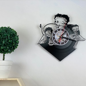 Può includere: Orologio in vinile nero e bianco con un'immagine di cartone animato di Betty Boop e un quadrante con numeri romani.