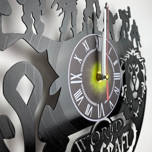 Puede incluir: Reloj de vinilo negro con una silueta de personajes del videojuego World of Warcraft. La esfera del reloj tiene n&uacute;meros romanos y un centro dorado. El reloj est&aacute; decorado con las palabras "World of Warcraft".