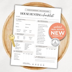 Op de afbeelding: Een witte checklist voor het zoeken naar een huis met zwarte tekst, met secties voor eigendomsdetails, woningevaluatie en locatiecontrole. Een goudkleurige sleutel ligt aan de linkerkant en er is een ronde koraalkleurige sticker bevestigd.