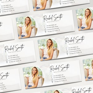 May include: A white business card with a gray background and a circle in the upper right corner. The circle contains a photo of a woman holding a cup. The text "Rachel Smith Real Estate Agent" is in black cursive font. The phone number, email address, and physical address are listed below the name.