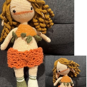 Puede incluir: Dos muñecas de crochet con cabello castaño, que llevan atuendos de calabaza naranja y verde. Las muñecas tienen hilo blanco para su piel e hilo marrón para sus ojos.