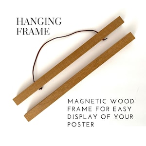 May include: Wooden hanging frame with a brown cord. The frame is made of two wooden strips with magnets for easy display of posters. The text "HANGING FRAME" and "MAGNETIC WOOD FRAME FOR EASY DISPLAY OF YOUR POSTER" are visible.