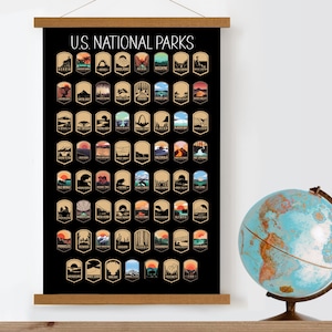 Pu&ograve; includere: Un poster nero e marrone con il testo "U.S. National Parks" in alto. Il poster presenta 63 illustrazioni colorate di loghi di parchi nazionali, ognuno con un design unico che rappresenta un parco diverso.