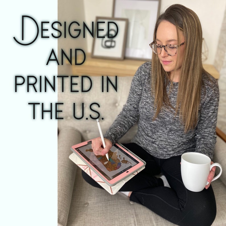 May include: A person is seated, holding a white mug and a tablet with a stylus. The tablet displays a map design. The text "Designed and Printed in the U.S." is visible in the image.
