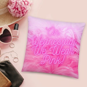 May include: Pink throw pillow with a fluffy pink texture and the text "On Wednesday We Wear Pink!" in a neon pink font.
