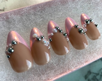 Uñas francesas con punta de almendra media y cromo rosa con perlas blancas y plateadas
