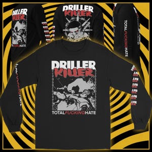 Puede incluir: Camiseta negra de manga larga con el texto "DRILLER KILLER" en blanco y rojo. La camiseta presenta un gráfico de una persona y el texto "TOTAL FUCKING HATE". Las mangas también tienen texto. La camiseta se muestra sobre un fondo amarillo y negro.