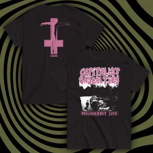 May include: Two black t-shirts with pink graphics. One features a figure on a cross, the other has the text "CAPITALIST CASUALTIES" above a grayscale image and the text "DISASSEMBLY LINE".