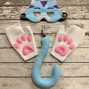 Puede incluir: Una máscara de gato azul claro con detalles morados, dos guantes blancos sin dedos con almohadillas de fieltro rosa y una cola de gato de felpa azul claro con un clip de metal. Un conjunto de accesorios para un disfraz.