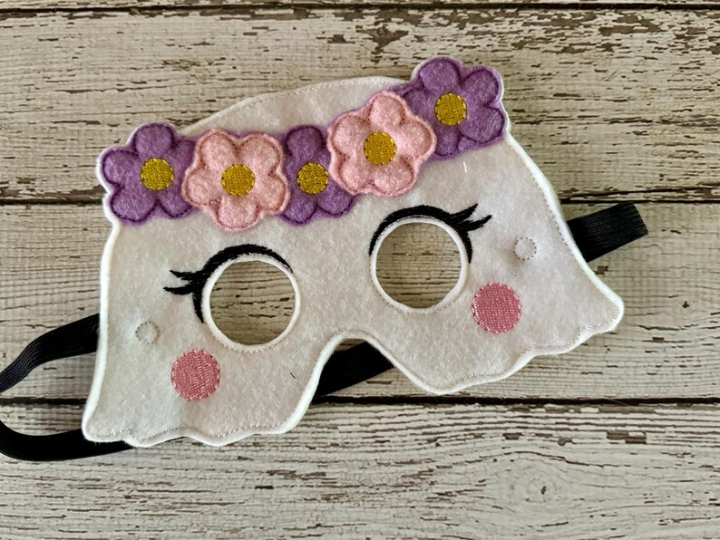 May include: White felt ghost mask with pink and purple flower accents and black elastic strap.
