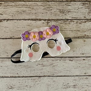 May include: White felt ghost mask with purple and pink flower embellishments around the eyes. The mask has black elastic straps.