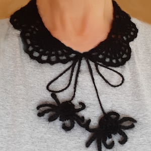 Puede incluir: Un collar de ganchillo negro con un lazo y dos ara&ntilde;as de ganchillo colgantes.