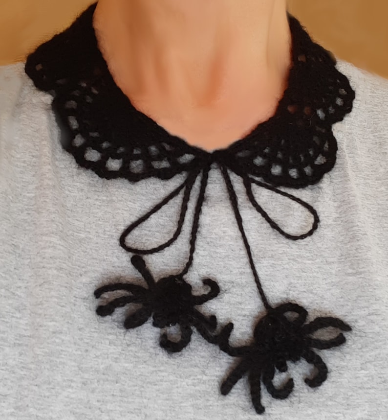 Puede incluir: Un collar de ganchillo negro con un lazo y dos ara&ntilde;as de ganchillo colgantes.