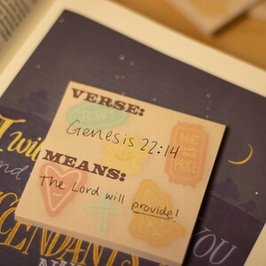 May include: A pink and yellow sticky note with the text "VERSE: Genesis 22:14 MEANS: The Lord will provide!"  The note has a heart, a cross, and a star design.